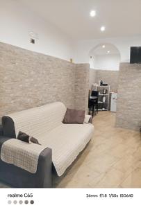 a couch in a room with a brick wall at Loft Deluxe Clary in Bari