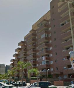 un gran edificio de apartamentos con coches aparcados en un aparcamiento en Oropesa del Mar, en El Borseral