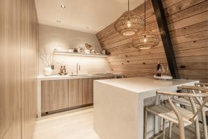 a kitchen with wooden walls and a counter with stools at Lafa Cabin - Luxe A Frame Retreat with Hot Tub, Sauna, Firepit- 5 Min to Mt Rainier in Ashford