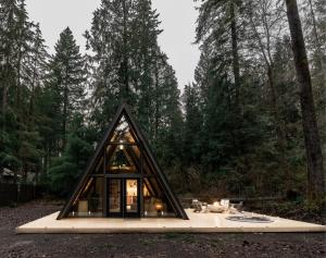 a frame house in the middle of a forest at Lafa Cabin - Luxe A Frame Retreat with Hot Tub, Sauna, Firepit- 5 Min to Mt Rainier in Ashford