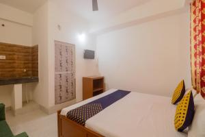 Un dormitorio con una cama con almohadas amarillas. en SPOT ON Hotel Om Kanha, en Bilāspur