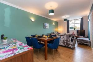 Una sala de estar con una mesa y sillas azules. en Town Centre Spacious Apartment with Private Parking, en Middlesbrough