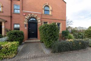 un edificio de ladrillo con una puerta negra. en Town Centre Spacious Apartment with Private Parking, en Middlesbrough
