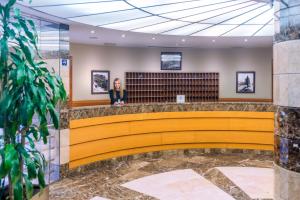 a woman sits at a waiting area in a lobby at Hotel & Aparthotel Cosmos in Andorra la Vella +87 photos