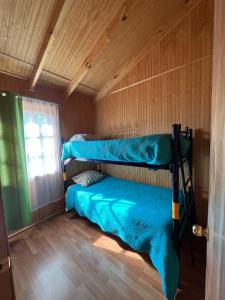 a room with two bunk beds and a window at Cabañas lo de Carlo in Puerto Tranquilo