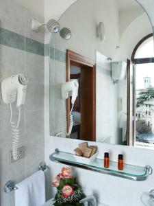La salle de bains est pourvue d'un lavabo et d'un miroir. dans l'établissement Hotel Windsor Savoia, à Assise