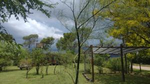 a park with a tree and a wooden structure at Cabaña en Villa Amancay in Villa Amancay