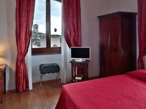 a bedroom with a red bed and a window at Hotel Windsor Savoia in Assisi