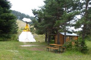 a tent and a picnic table in a field at Tipi NCO in Caille