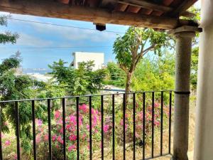 a balcony with pink flowers and a fence at Casa Pajaros - Skyview in Cruz de Huanacaxtle