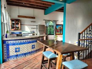 a kitchen with a wooden table and blue and white tiles at Casa Pajaros - Skyview in Cruz de Huanacaxtle +14 photos