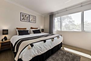 a bedroom with a large bed and a large window at Fox on Church in Hepburn Springs