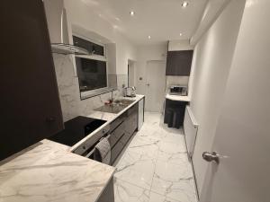 Una cocina blanca con fregadero y encimera. en Luxe Guesthouse, en Stoke on Trent