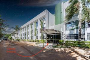a large white building with an orange arrow in front of it at Studio de Luxo Provençal in Brasilia