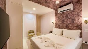 a bedroom with a white bed and a wall at Studio de Luxo Provençal in Brasilia