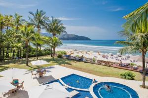 uma vista aérea da praia e da piscina num resort em Amora Hotel Maresias em Maresias