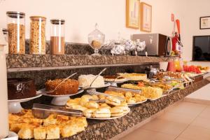 a buffet line with many different types of food at Hotel Conceição in Linhares