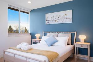 a bedroom with blue walls and a bed with two lamps at Wallingford Getaway in Seattle