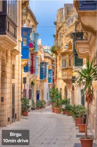 an empty street in an old town with buildings at Country View Retreat in Żabbar