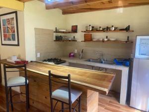 a kitchen with a sink and a counter with stools at Cabaña Paty in Mazamitla