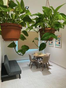 a dining room with a table and two potted plants at دار نوره وحدة سكنية في منتصف جدة in Jeddah