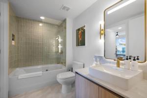 un bagno con vasca, WC e lavandino di Upscale 3-BD Condo in Downtown Miami a Miami