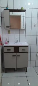 een witte badkamer met een wastafel en een spiegel bij Casa Denis in Pântano Grande