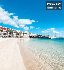 a view of a beach with buildings and the ocean at Country View Retreat in Żabbar