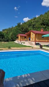 a house with a blue swimming pool in front of a house at Milica 1 Mezdrejska 87 in Kalna