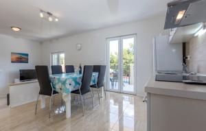 a kitchen and dining room with a table and chairs at Apartments Dalis in Milna