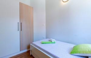 a small bedroom with a bed and a cabinet at Apartments Dalis in Milna