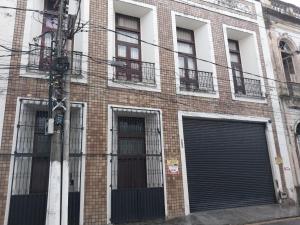 a brick building with two garage doors and windows at Casa Merlini - Hotel e salas Comerciais in Belém