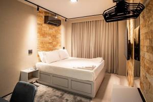 ein Schlafzimmer mit einem Bett, einem Tisch und einem Stuhl in der Unterkunft Studio de Luxo Urban in Brasilia