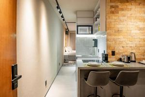 eine Küche mit einer Theke und Stühlen in einem Zimmer in der Unterkunft Studio de Luxo Urban in Brasilia + 126 Fotos