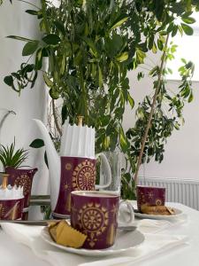 a table with two coffee mugs and a plate of cheese at O5 residence in Nivy