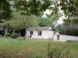 a small white house in the middle of a yard at Maisonnette à la campagne in La Couyère