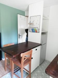 a kitchen with a wooden table and a chair at Maisonnette à la campagne in La Couyère