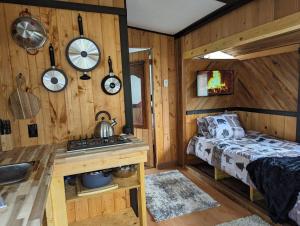 a bedroom with a bed and a sink in a room at Cozy Beachfront Cabin at Woodside Farm in Sooke