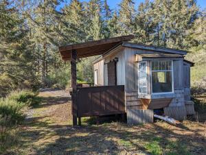 a tiny house sitting in the middle of a field at Cozy Beachfront Cabin at Woodside Farm in Sooke