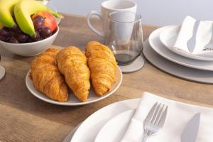 ウォルヴァーハンプトンにあるWolverhampton Luxury City Centre Apartmentのクロワッサン一皿とフルーツ一杯のテーブル +14枚の写真