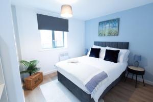 ウォルヴァーハンプトンにあるWolverhampton Luxury City Centre Apartmentの大型ベッドと鉢植えの植物が備わるベッドルーム1室