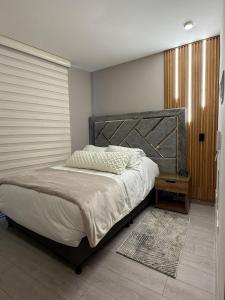 a bedroom with a large bed with a wooden headboard at Aparta studio area downtown Bogotá in Bogotá