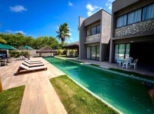 a swimming pool in front of a house at Manah Milagres in São Miguel dos Milagres