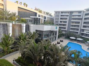 an apartment building with a swimming pool and palm trees at Sheraton Ocean 7-PRIVATE SUITES - Without Pool access in Cairo