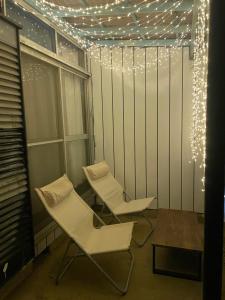 结城市One room Pusang Gala Yuki City的两个白色椅子,房间带圣诞灯