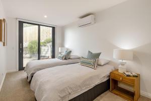 two beds in a room with a window at Back Beach in Portsea +28 photos