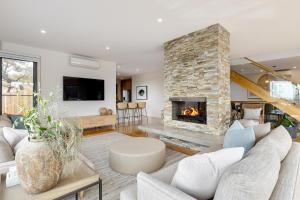 a living room with a large stone fireplace at Back Beach in Portsea