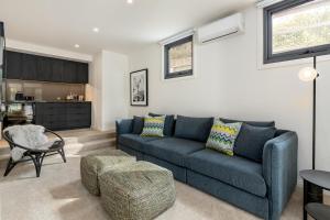 a living room with a blue couch and a table at Back Beach in Portsea
