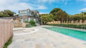 a house with a swimming pool and a fence at Back Beach in Portsea