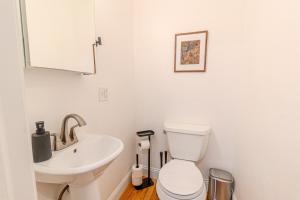 a white bathroom with a sink and a toilet at 4BDR Near Tufts-10min-Walk to Subway-Free Parking in Somerville